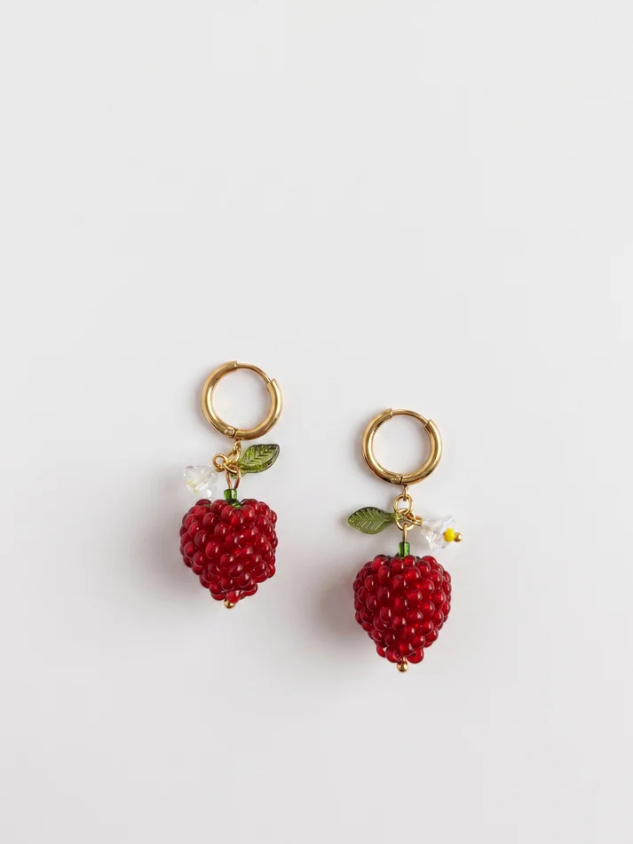 Flat phone photo of a pair of red beaded raspberry earrings on a plain white surface