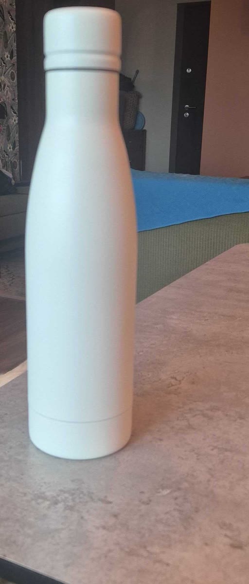 Phone photo of a plain white water bottle on a kitchen table